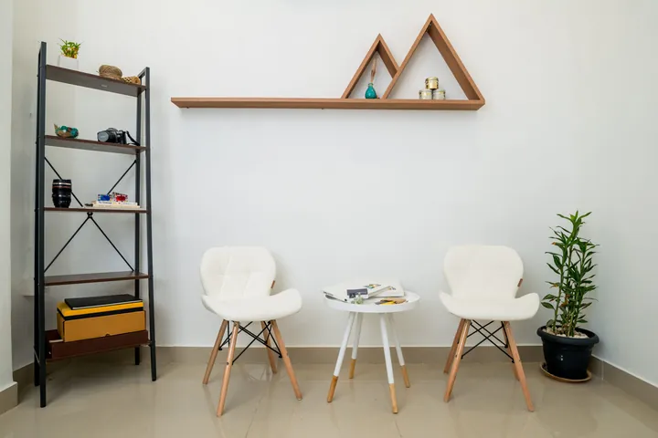 A bright corner of The Affordable Place coworking space with white chairs and shelves