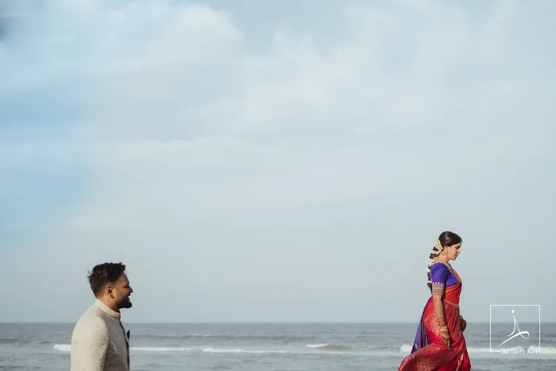 A bride and groom walking towards each other on a beach